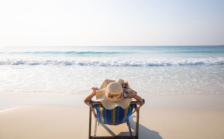 Woman relaxing in lawn chair on beach