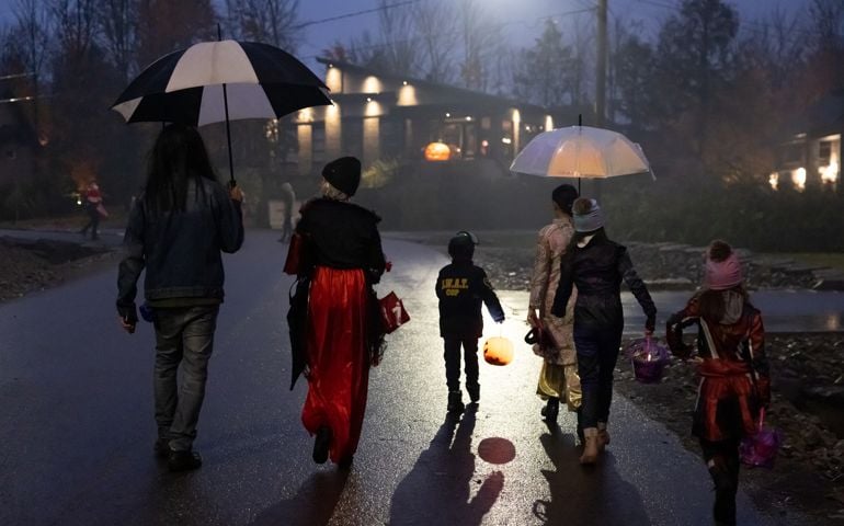Group of People walking on illuminated street on Halloween night