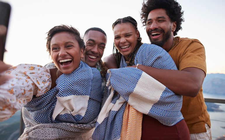 Woman taking selfie with friends on mobile phone