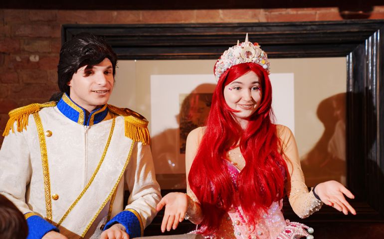 actors in costumes of a prince and a mermaid at a children's party.