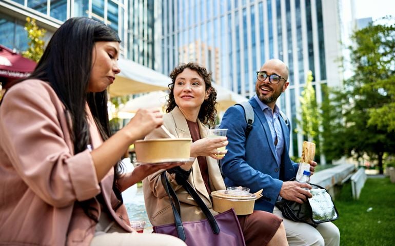Office workers eating lunch together