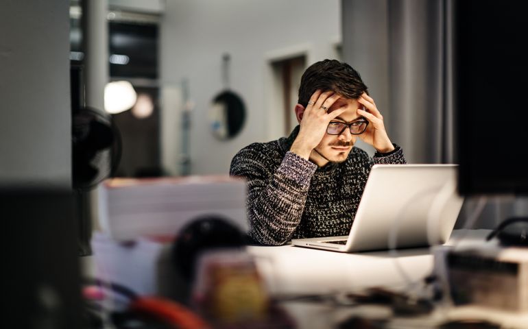 Young businessman holding his head and pondering