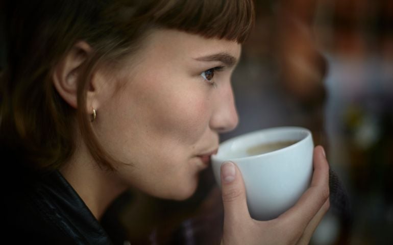 Young woman drinking cup of coffee