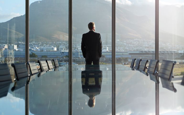 Portrait of male CEO in big corner office, looking out of window