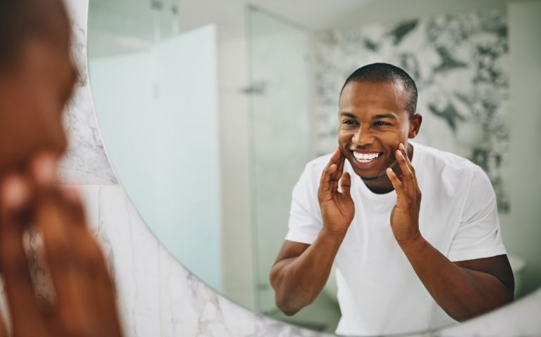 man smiling looking at the mirror