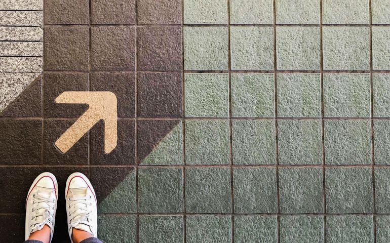 Woman sneaker shoe and Arrow on street with copy space background