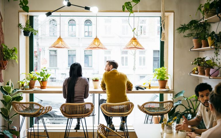 Couple Sitting By Window In Quirky Café