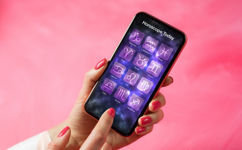 Person reading daily horoscope on mobile phone