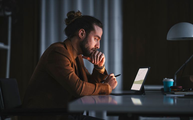 Pensive man working on laptop in office