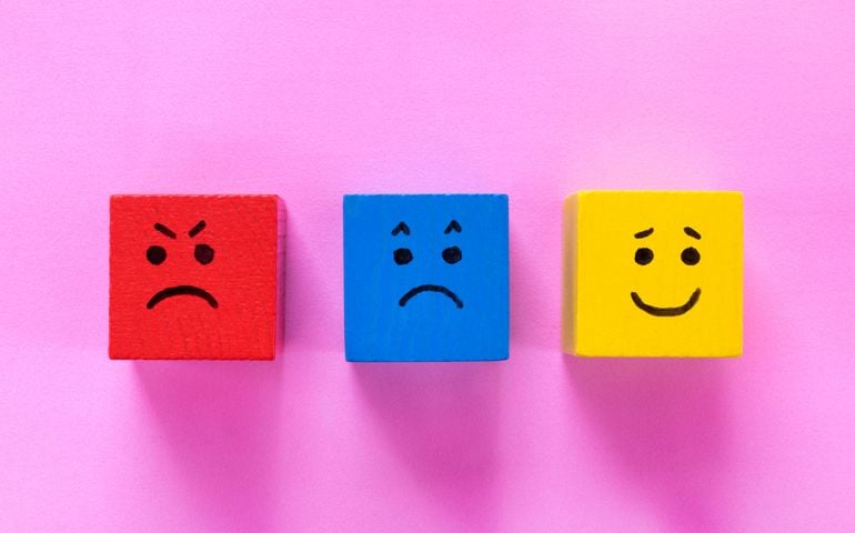 Cubes with cute faces depicting human emotions: anger, sadness and happiness