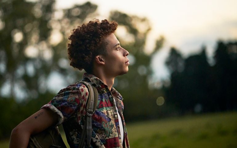 Portrait of mid 20s African-American man outdoors at dusk