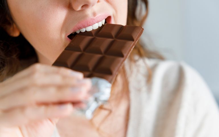 Woman biting a chocolate bar
