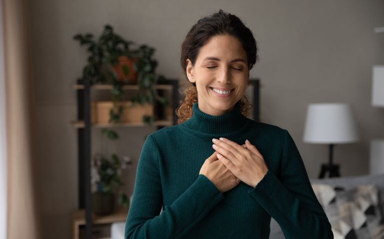 woman hold hands on heart feeling grateful