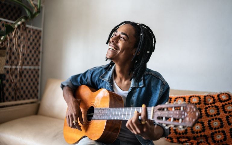 Young man playing guitar at home