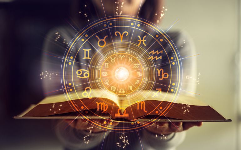 Woman holding a astrology book. Astrological wheel projection, choose a zodiac sign. Astrology esoteric concept.