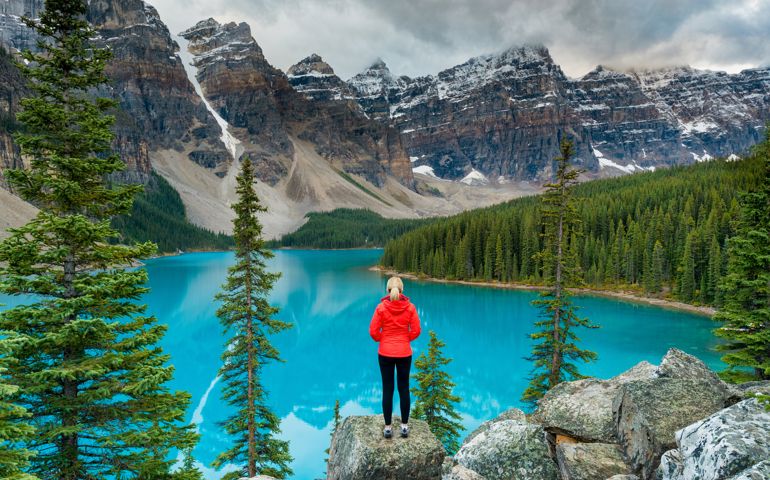Female hiker stood looking over Lake Moraine, Banff National Park, Canada