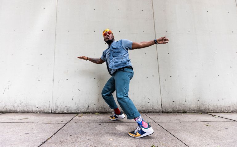 Fashionable male professional dancer on urban sidewalk, full length