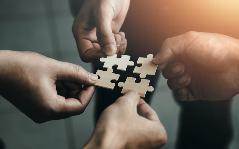 people holding jigsaw pieces