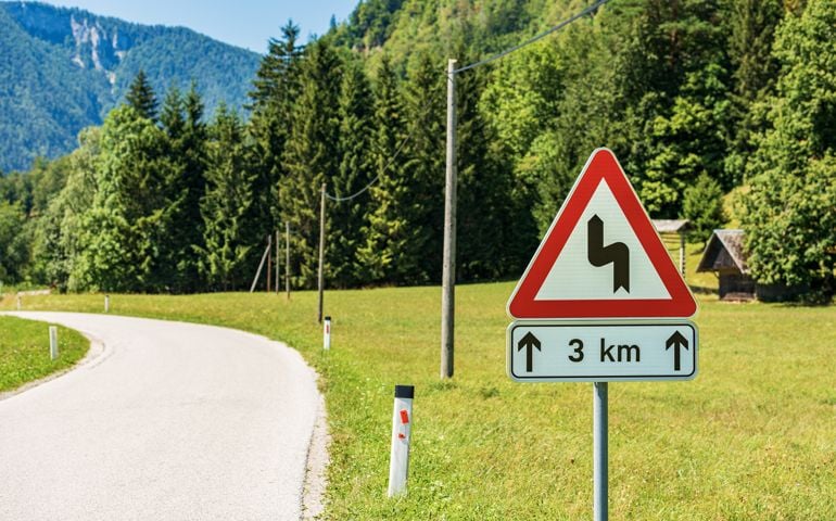 Triangular Road Sign of Winding Roads Ahead - Road with Dangerous Curves