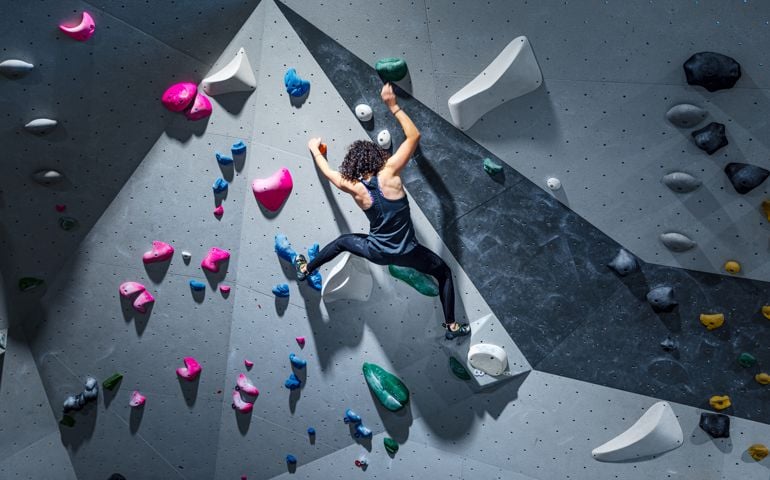 Sportswoman training climbing on indoor climbing wall