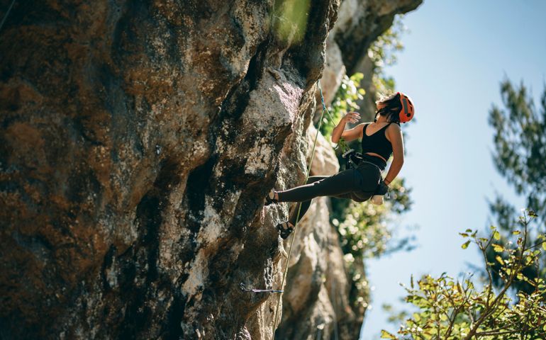 One Asian young climber woman climbing on the rock