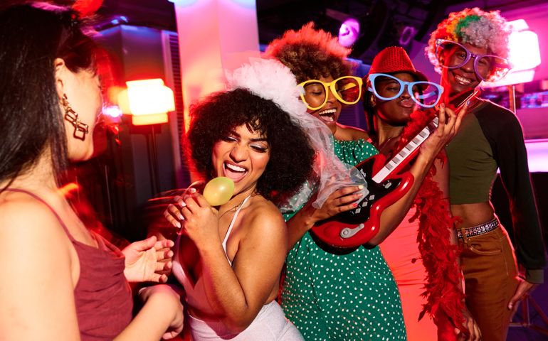 group of young people in costume at a bachelorette party singing and having fun in the discotheque
