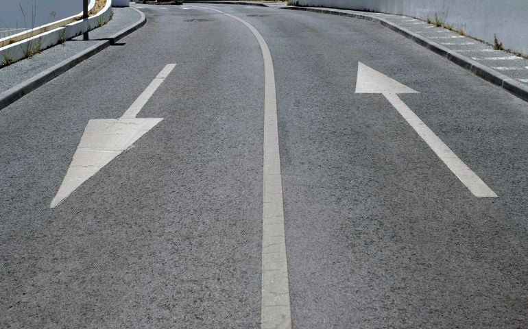 Road with two arrows pointing into opposite directions