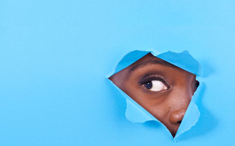 woman looking through blue curtain