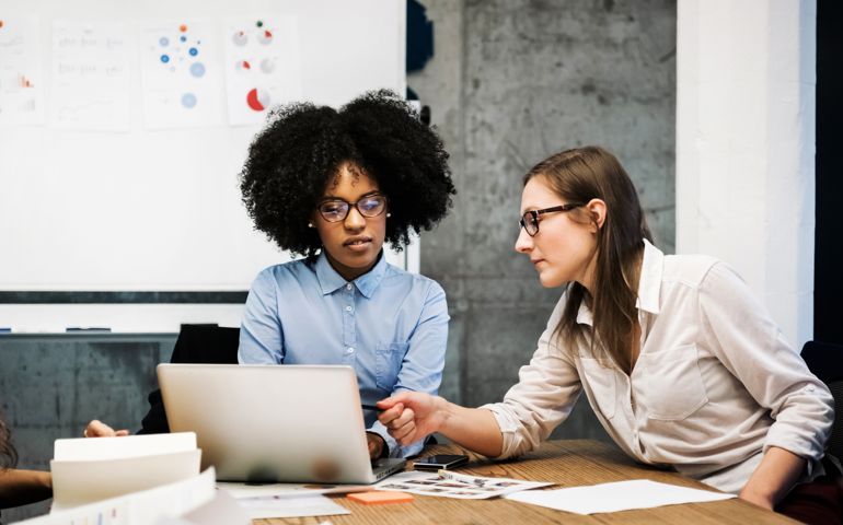 Two young women having a discussion in a business