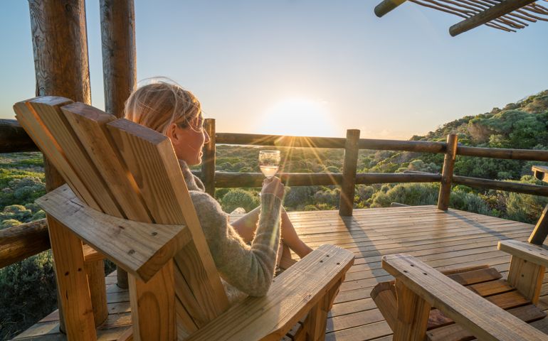 Young woman relaxing on terrace at sunset