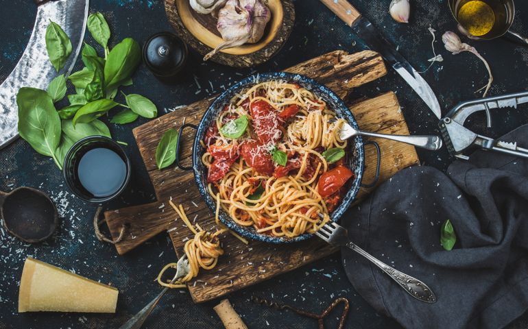 Spaghetti with tomato and basil and ingredients for making pasta