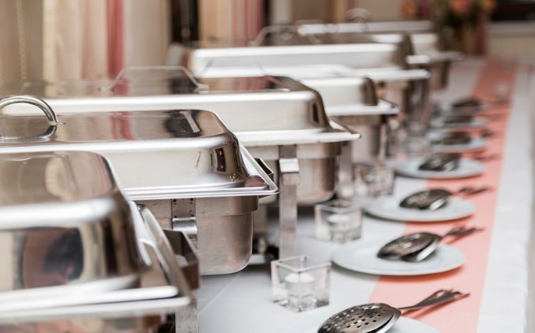 Many white metallic clean modern utensils on wedding buffet