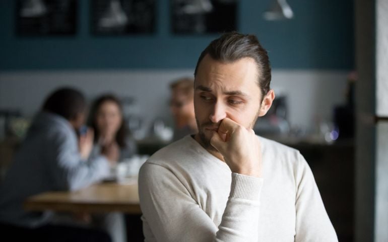 Upset male outcast feel lonely sitting alone in cafe