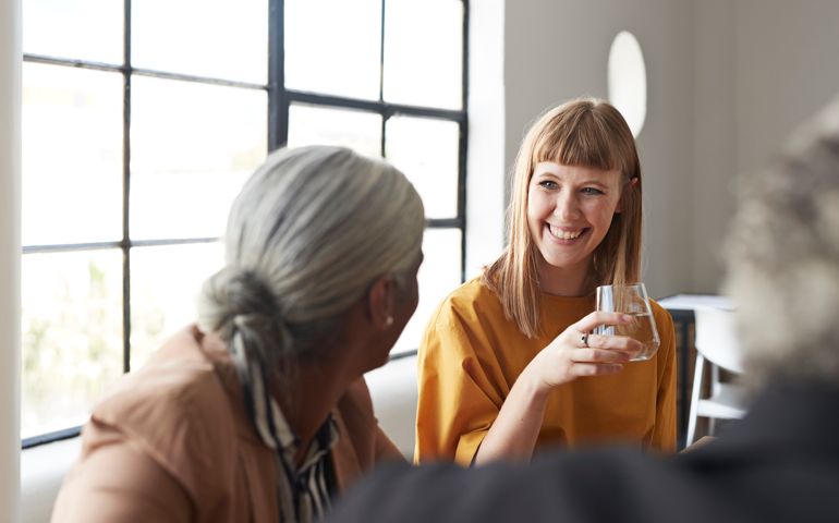Businesswoman with water by coworker at workplace