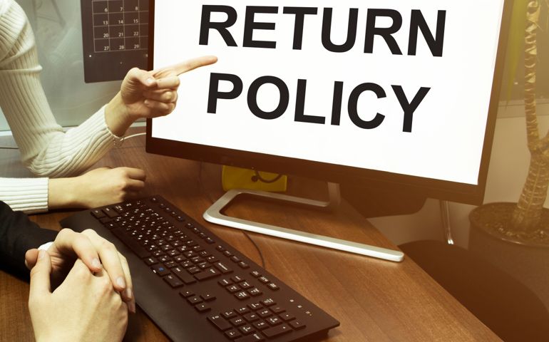 male and female hand, computer with text Return Policy with office background