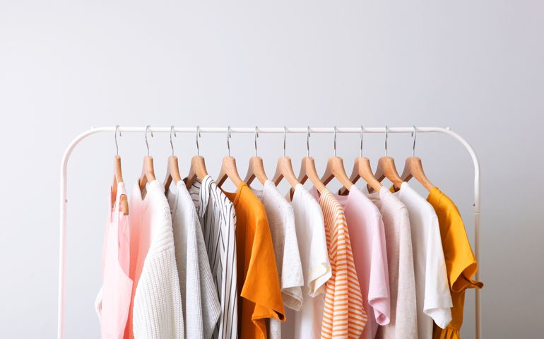 fashion clothes on a rack in a light background indoors. place for text