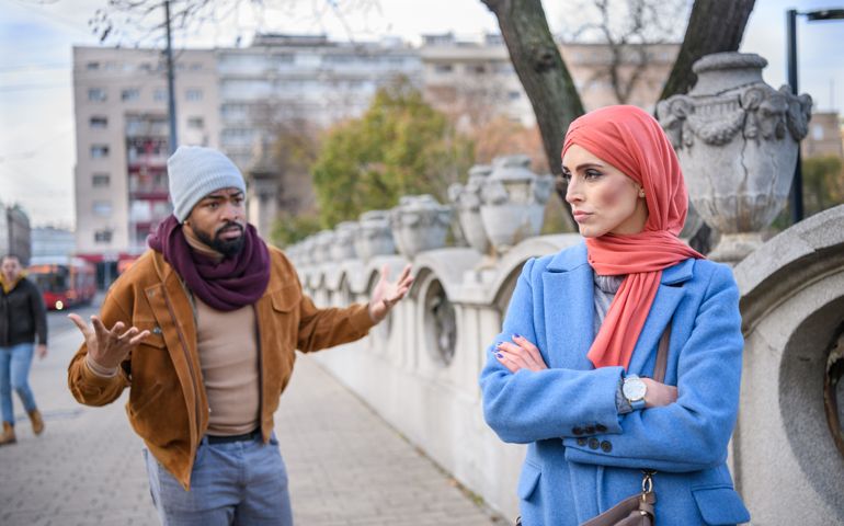 An African-American Man is Arguing with his Angry Muslim Wife During the Walk in the City District.
