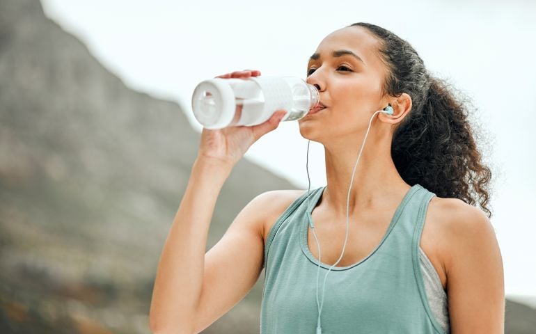 Shot of a young woman taking a break from working out to drink water