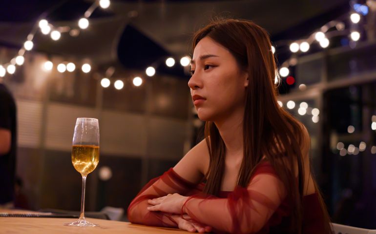 Young Asian woman feeling sad and heartbroken after breaking up with her boyfriend while sitting at restaurant