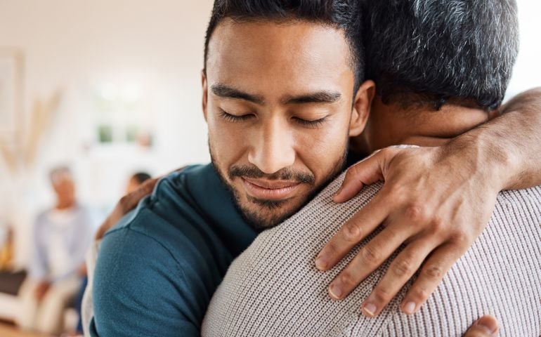 Shot of a father and son hugging at home