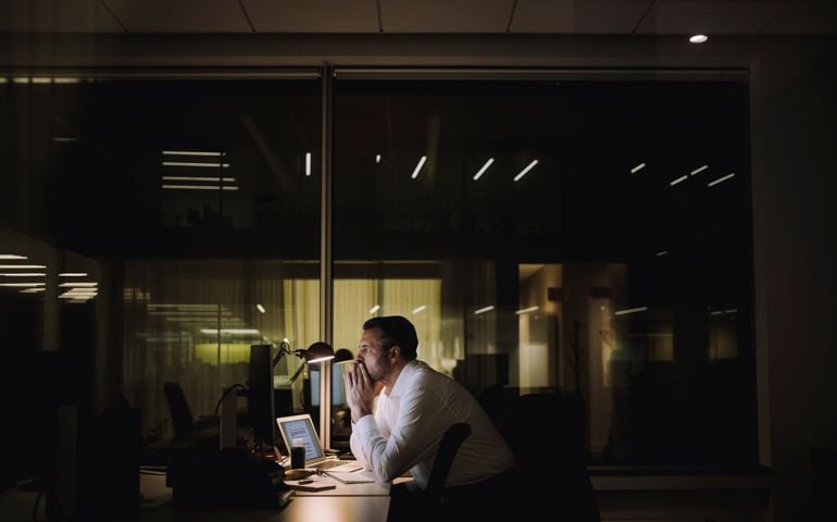 Businessman concentrating while working overtime in office at night