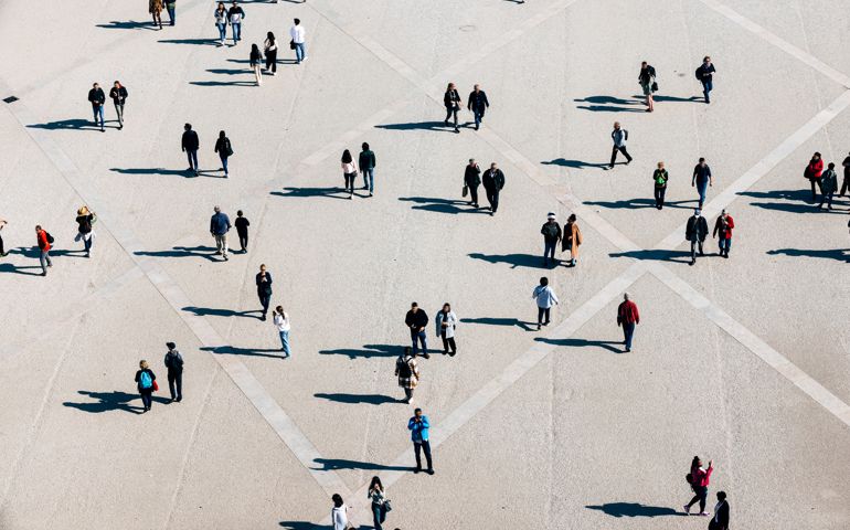 Aerial view of large number of people walking on the city square on the sunny day