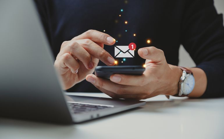Hand of businessman using smartphone for email with notification alert.