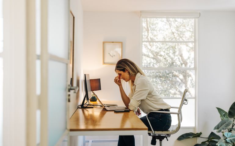 Exhausted businesswoman having a headache in her office
