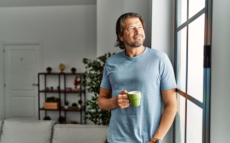 Middle age caucasian man smiling confident drinking coffee at home