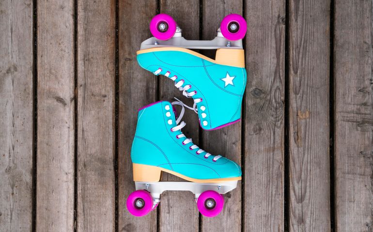 Multi colored roller skates on floorboard