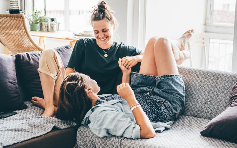 Female couple enjoying time together on a sofa.