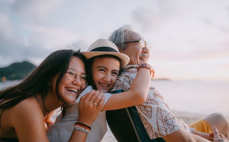 Grandfather and granddaughters having fun on beach