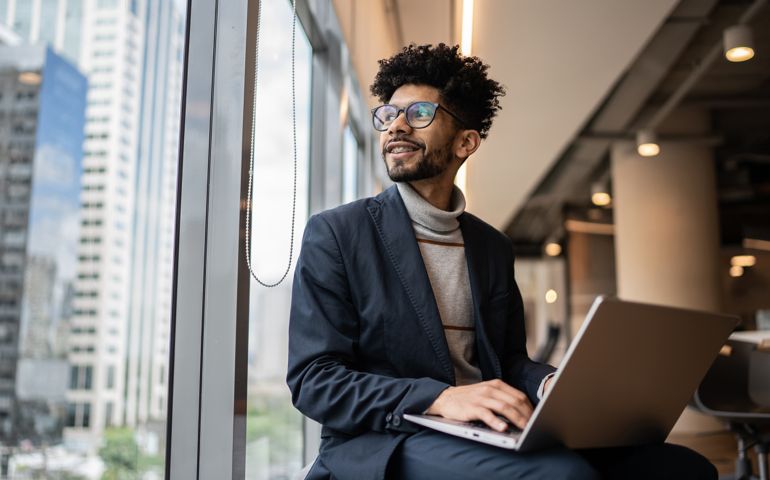 Businessman contemplating in the office looking through the window