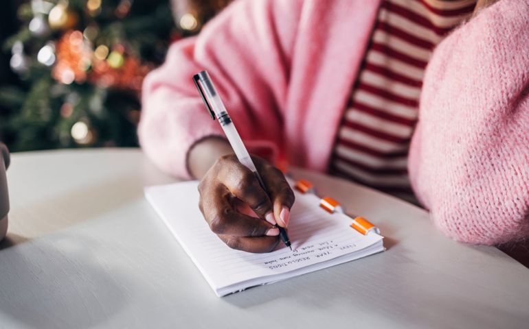 Woman Writing New Year's Resolutions